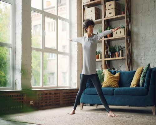 Person doing light stretching in a cozy living room