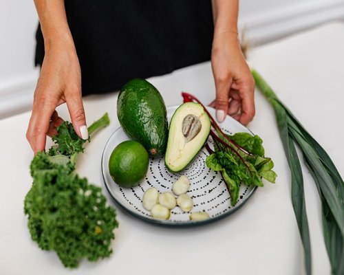 A healthy plate of food featuring fresh avocado, legumes, and vegetables